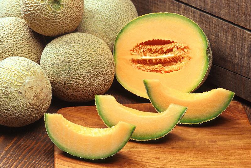 Cantaloupes with orange slices cut from one