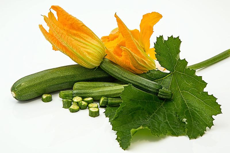 Zucchini with their yellow flowers and a leaf